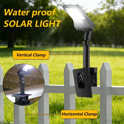 Black solar clip-on LED light with vertical and horizontal clamp brackets on a fence