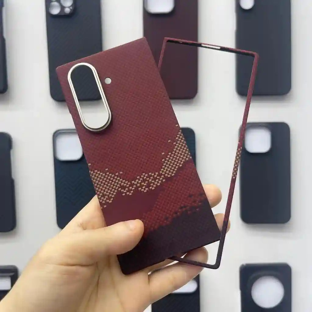 Textured burgundy phone case with an abstract pattern and a silver camera ring, shown with a detached matching frame.