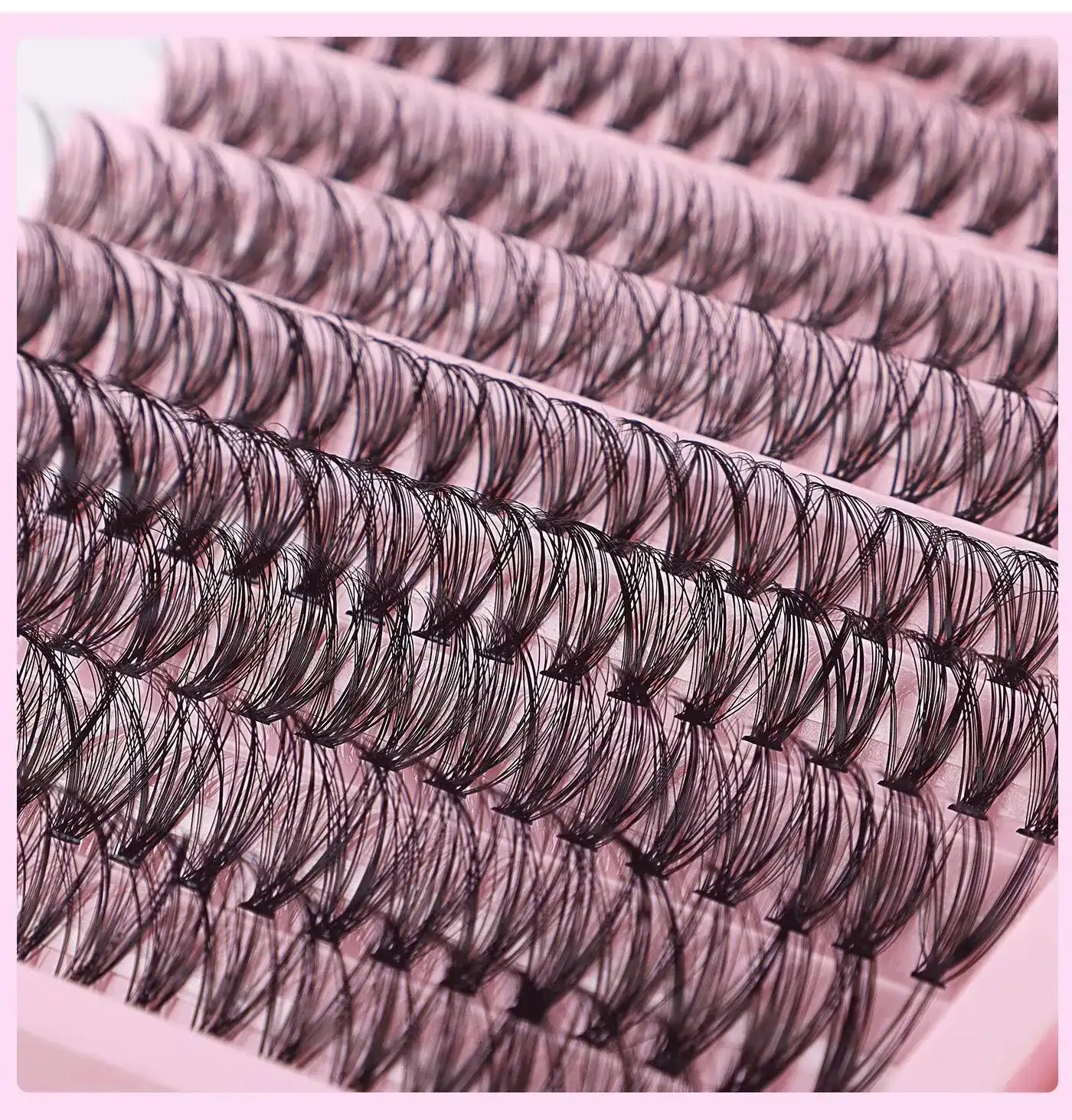 Rows of black DIY cluster lashes arranged on a pink tray, featuring varied lengths for a natural look.