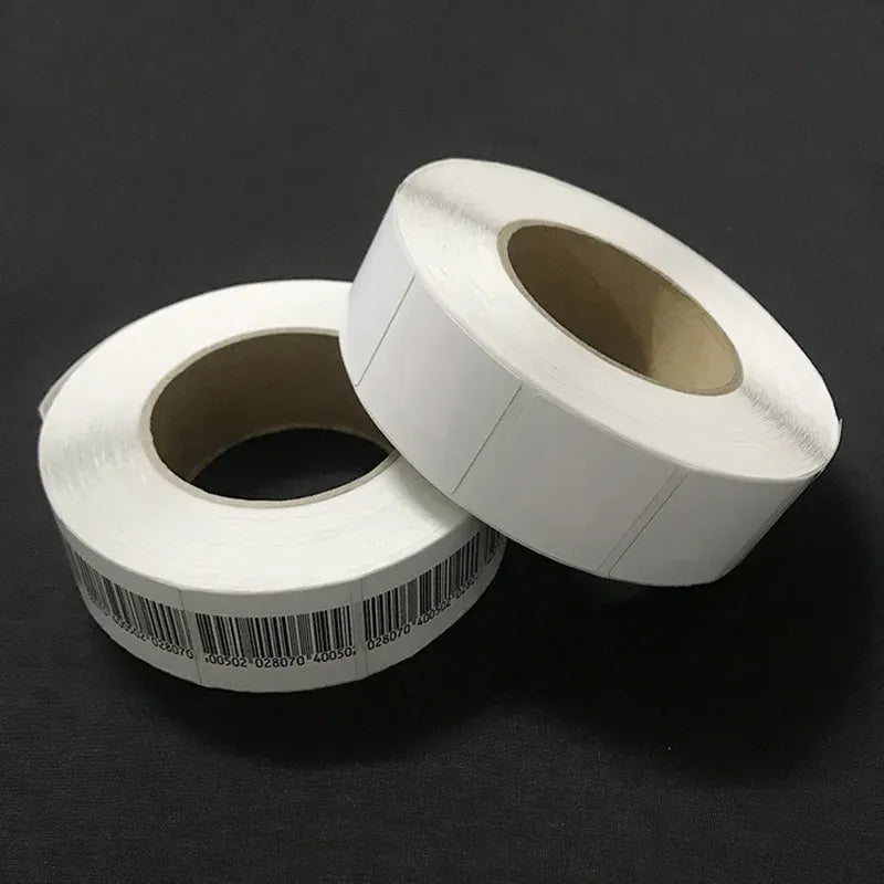 Two rolls of white RF EAS barcode soft labels with visible black barcodes