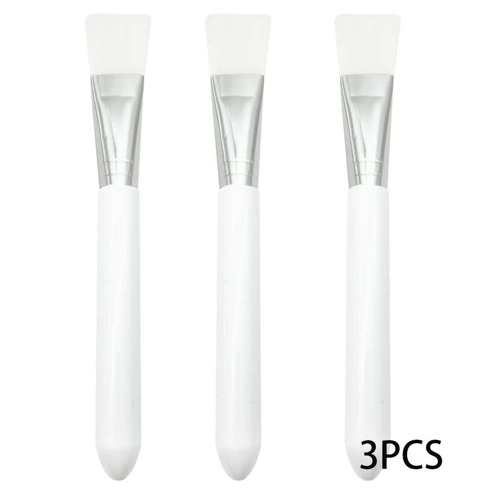 Set of 3 white silicone face mask brushes with silver ferrules and handles for applying facial skincare products.