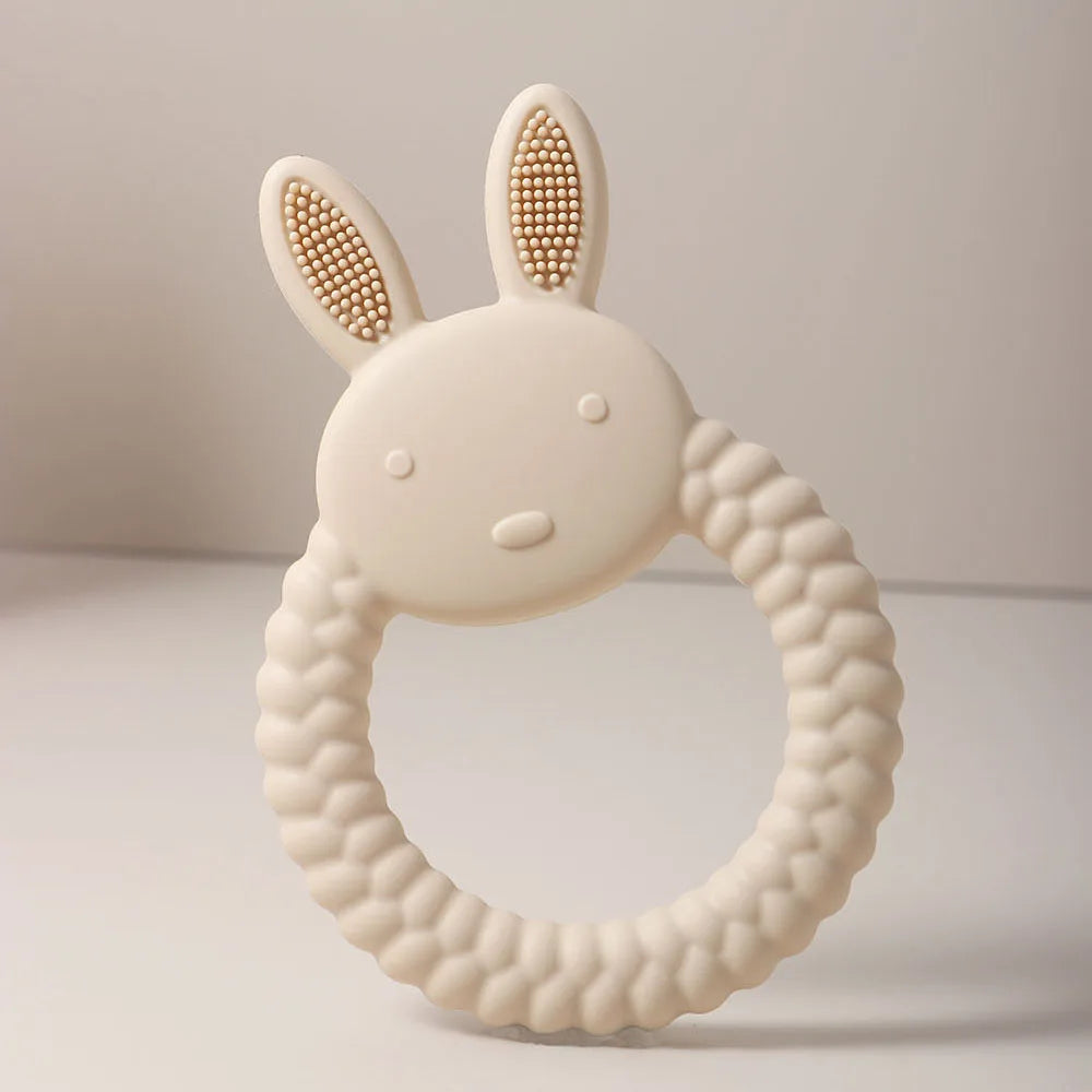 Beige silicone rabbit teething ring for baby teething relief.