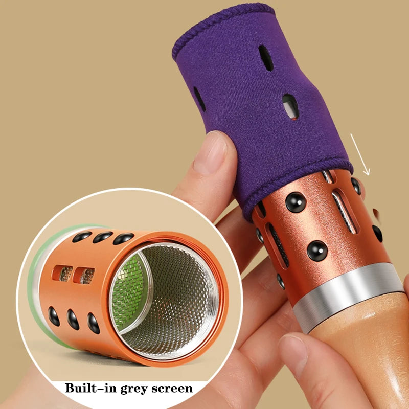 A moxibustion massager featuring a purple fabric sleeve, copper-tone metal body with black beads, and a mesh screen.