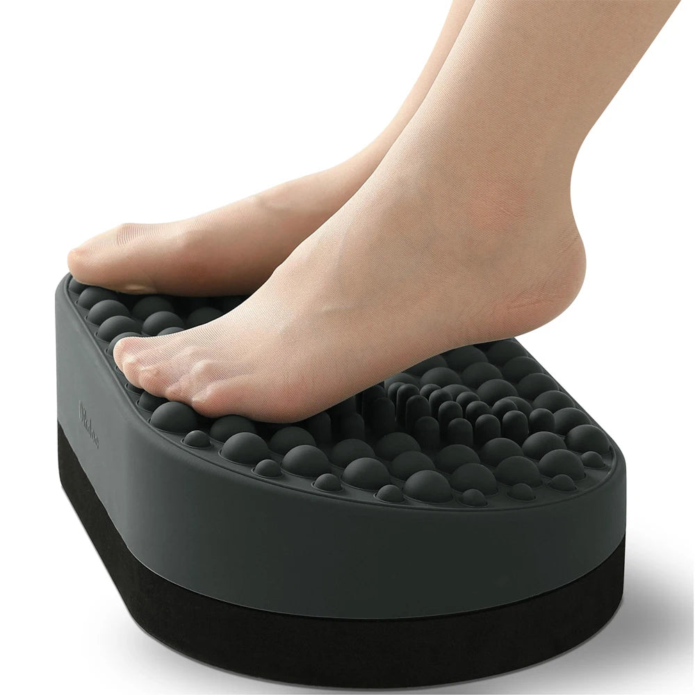 Grey silicone under-desk foot rest with massage nodes for plantar fasciitis relief and ergonomic home office support.