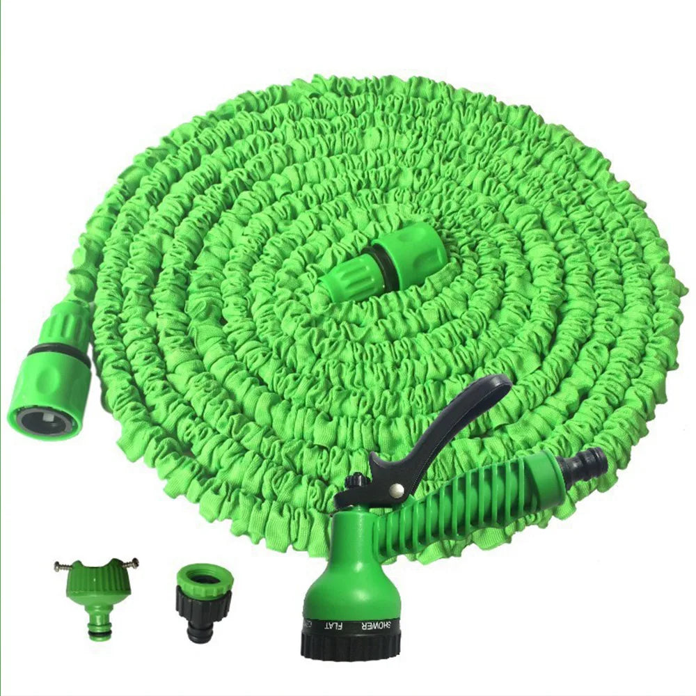 Green expandable garden hose with spray gun and multiple nozzle attachments