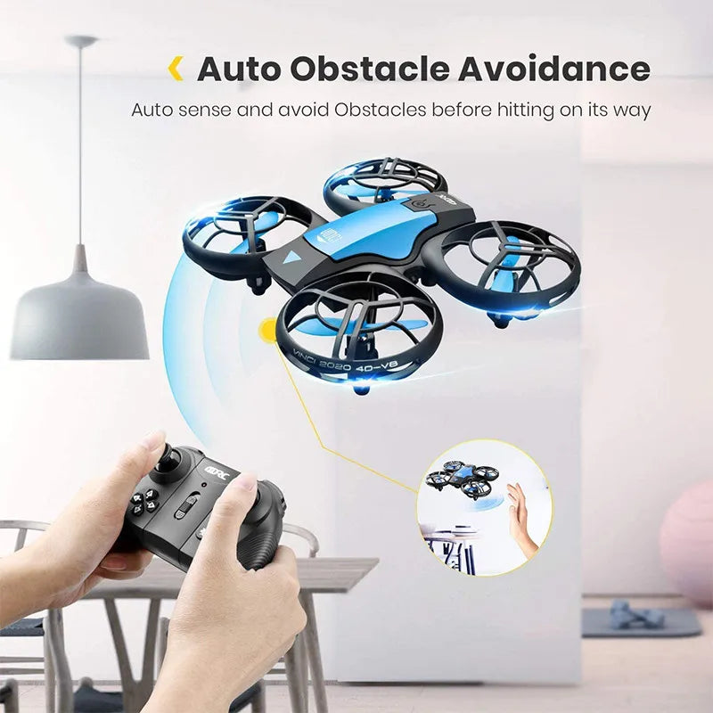 Small blue and black quadcopter drone with protective blade guards, controlled by a handheld remote for indoor flight.