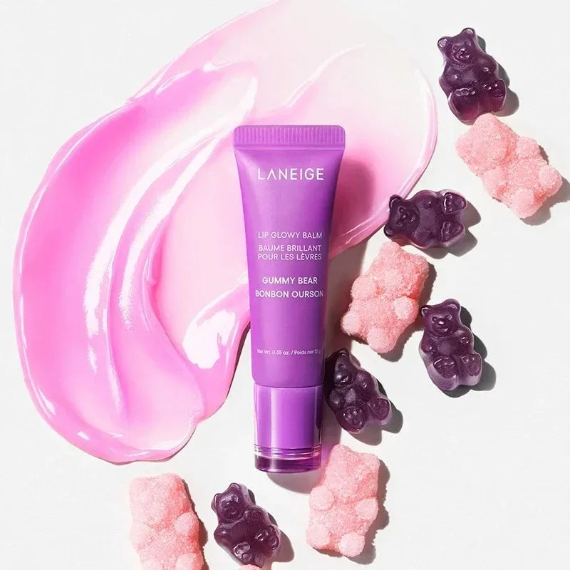 Laneige Gummy Bear Lip Glowy Balm in purple tube with pink glossy texture swatch and gummy bear candies.