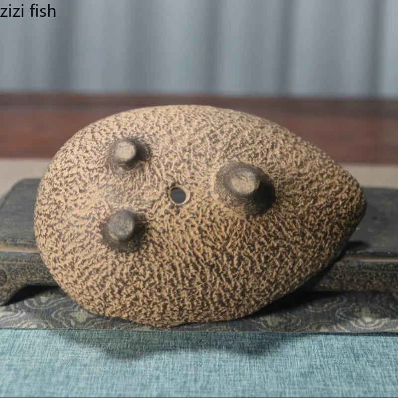 Ceramic planter with rounded top and multiple circular drainage holes on the surface