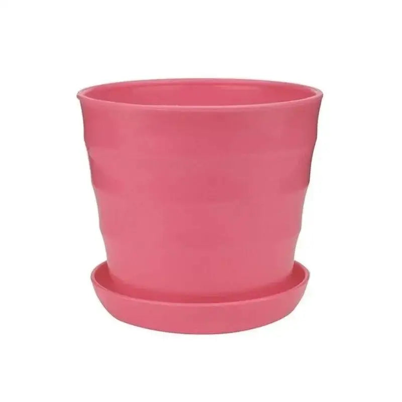 Pink plastic flower pot with matching saucer, smooth rounded container