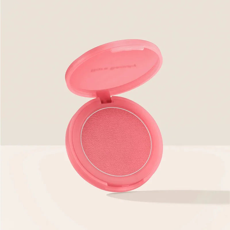 Rare Beauty powder blush in a pink compact with a smooth, matte-finish coral-pink powder.