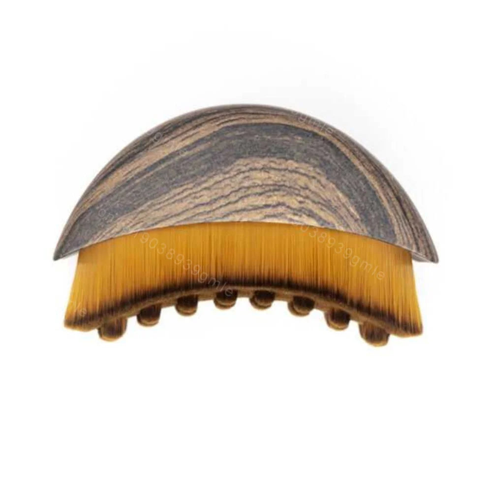 A semi-circular lymphatic contour brush with a dark wood-grain handle and dense, yellow-tipped synthetic bristles.