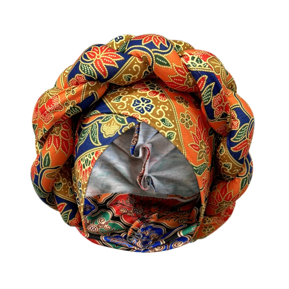 Tidesmit orange, blue, and gold floral print fabric turban with a thick, braided crown detail on a white background.