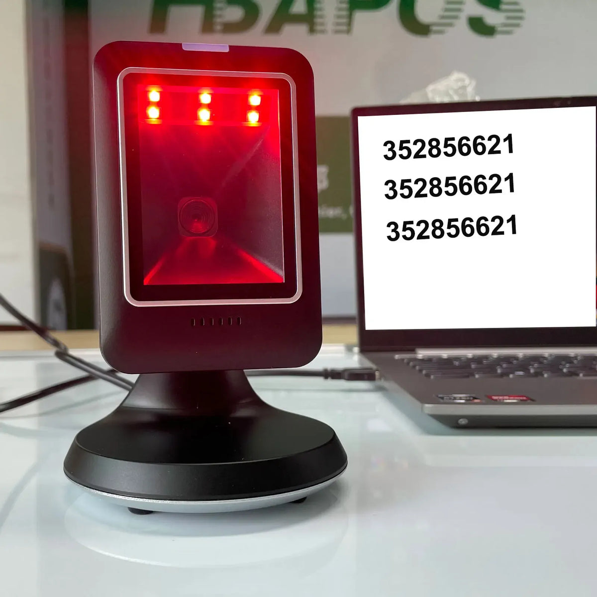 Close-up of red scan light on black desktop 2D barcode scanner with USB cable