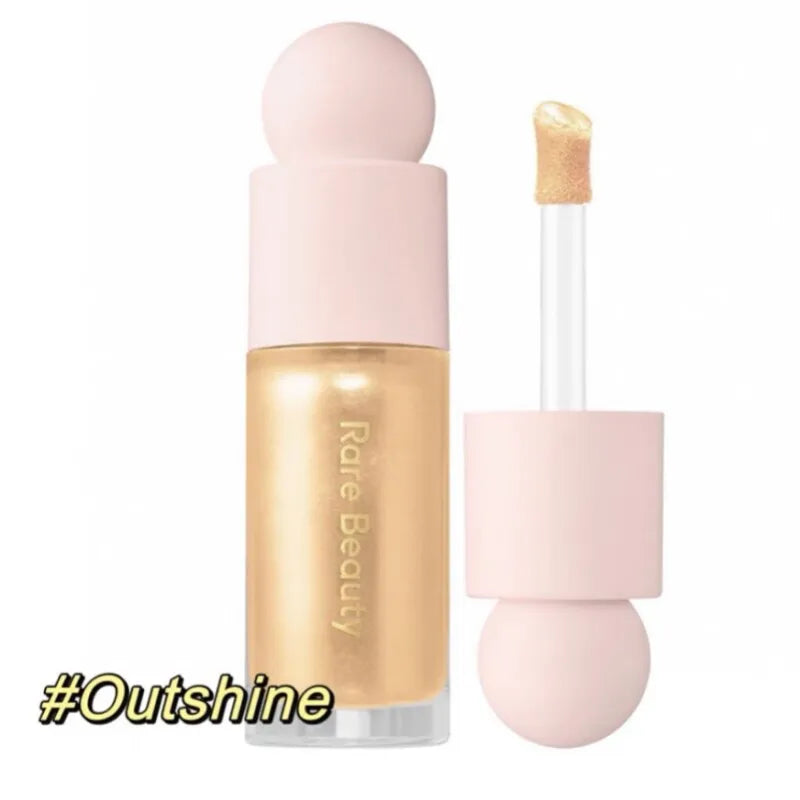 Gold Rare Beauty liquid highlighter stick with applicator wand for radiant, long-lasting glow on lips and cheeks.
