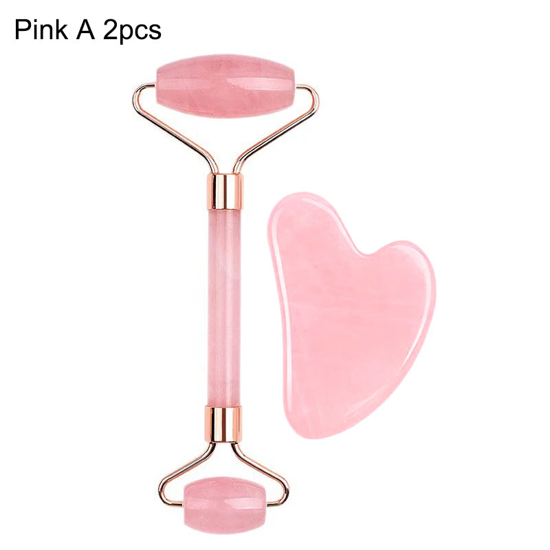 A pink rose quartz facial roller and heart-shaped gua sha massage tool on a white background.