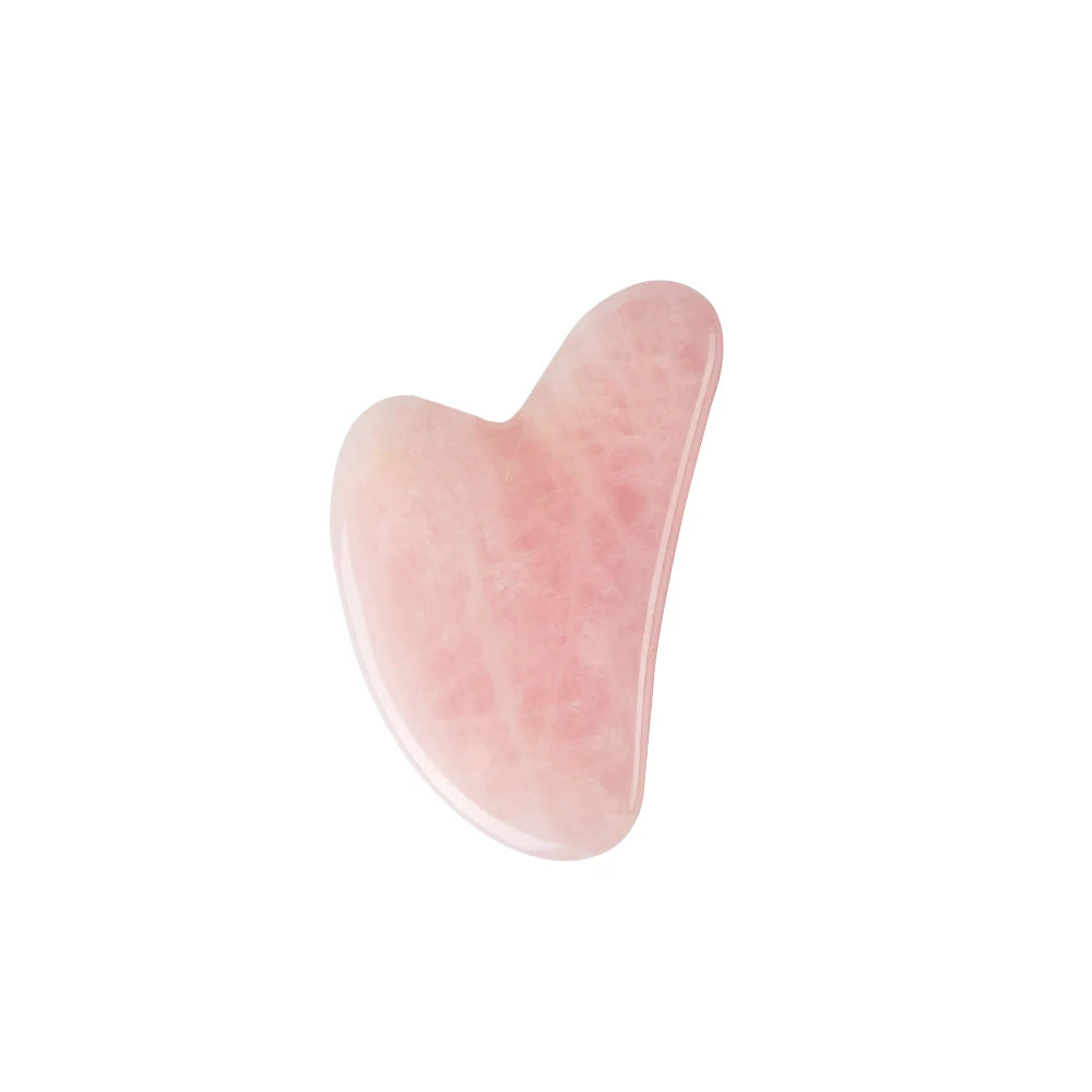 Heart-shaped rose quartz gua sha facial massage tool with a smooth, polished finish, isolated on a white background.