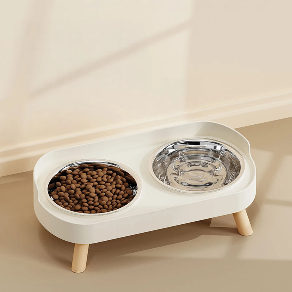 Elevated white dual pet feeder with stainless steel bowls for ergonomic, cervical-protecting cat and dog dining.