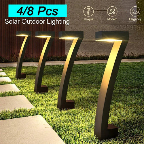 Solar path light set with 4 black stake lamps emitting warm yellow glow outdoors