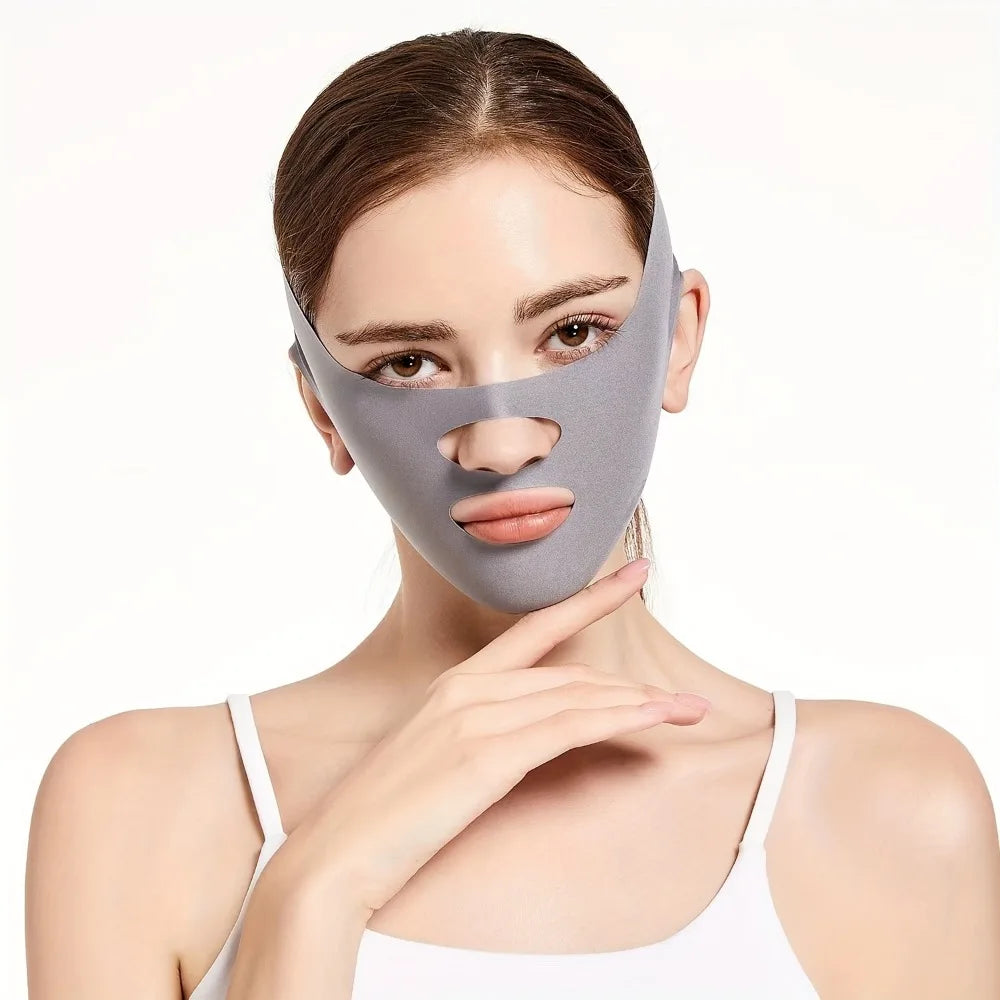 A woman wearing a gray, stretchy V-line face slimming bandage with cutouts for the nose and mouth.