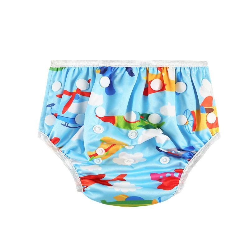 Reusable baby swim diaper in blue with colorful airplane print and adjustable snap buttons.