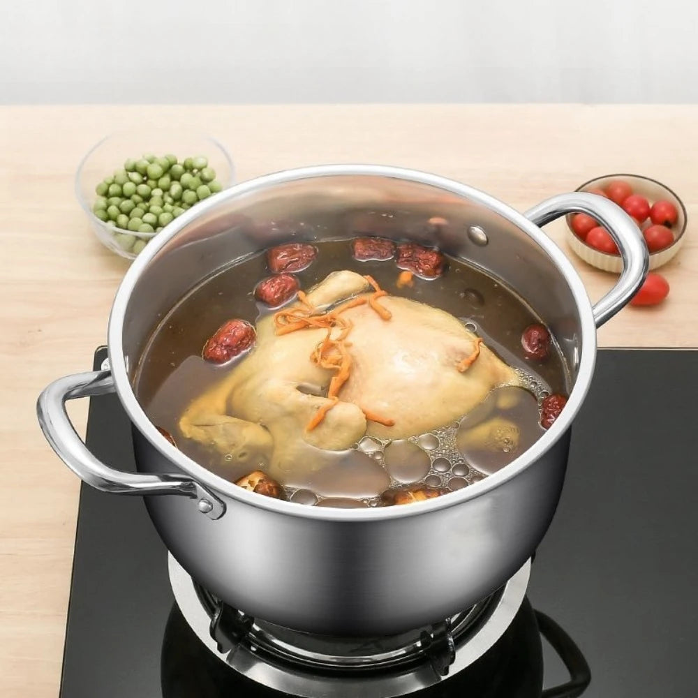 Stainless steel steamer pot with handles, filled with bubbling soup and chicken