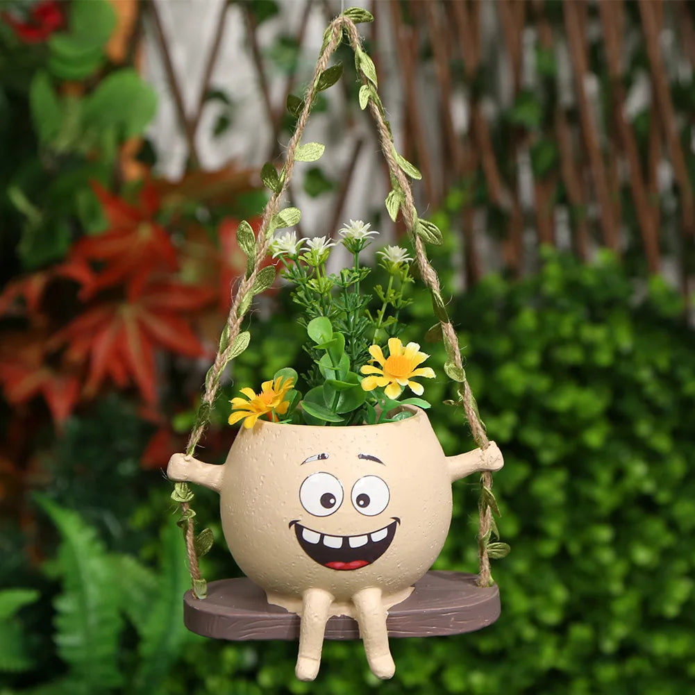 Hanging rocking swing face planter pot with green succulent and yellow flowers