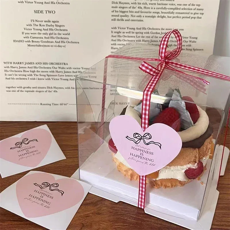 Round pink “HAPPINESS” custom stickers on packaged bakery treats with ribbon