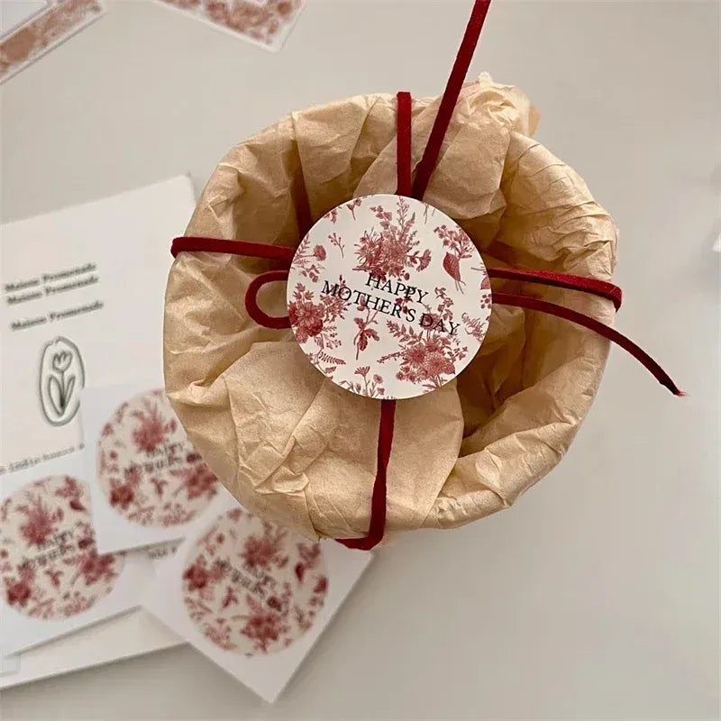 Round “Happy Mothers” sticker label on a brown tissue-wrapped gift.