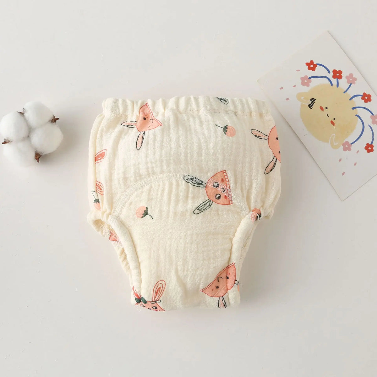 Cream cotton baby training diaper with cute bunny and strawberry print, soft breathable baby care underwear.