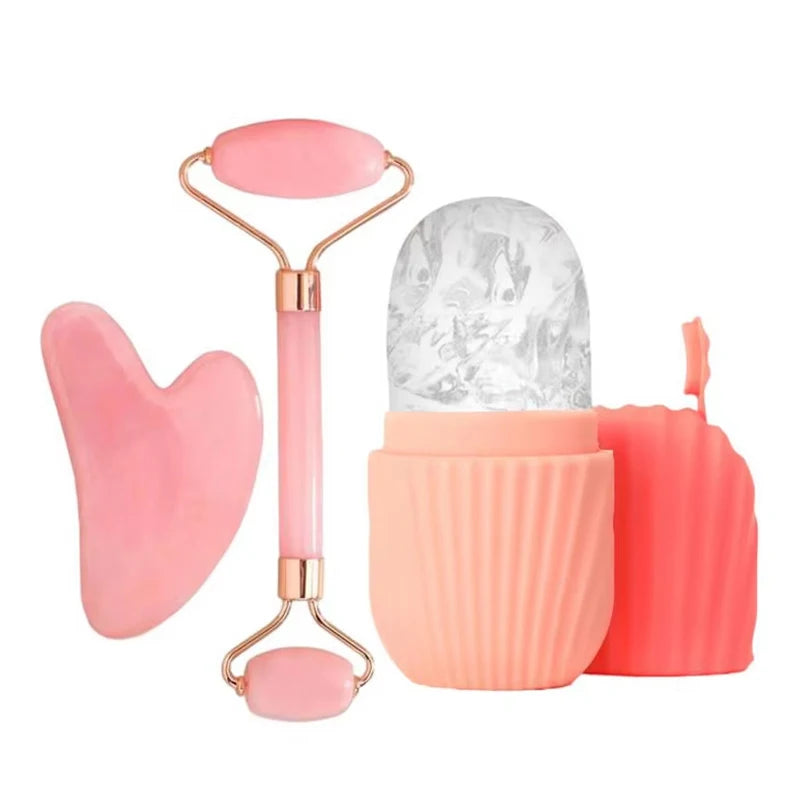 Skincare set with a pink heart-shaped gua sha, a dual-ended pink jade face roller, and a coral silicone ice face mold.