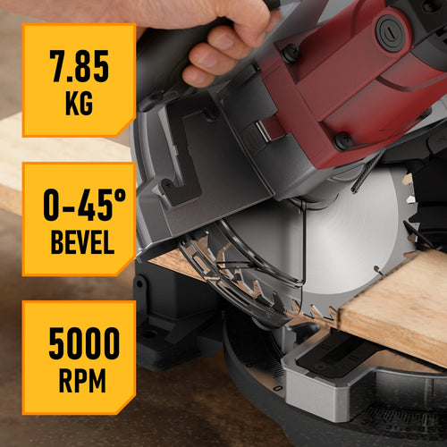 Electric compound miter saw cutting a wood board on a miter base