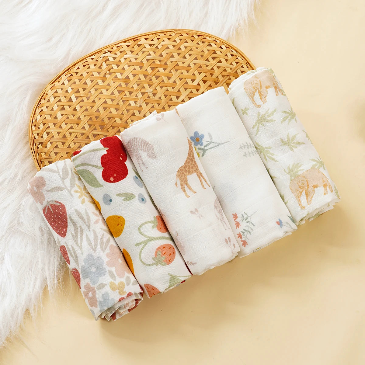 Set of 5 baby muslin swaddle blankets with cute animal and fruit prints, soft baby care essentials.