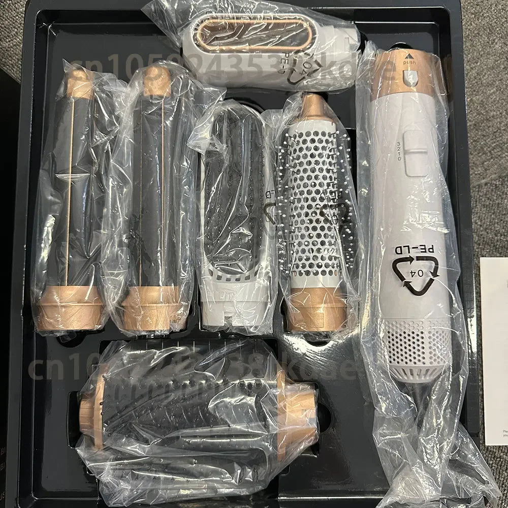 6-in-1 gold and white hair dryer brush set with curling iron and styling attachments in a professional storage tray.