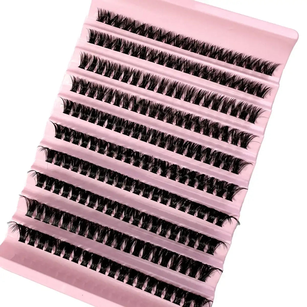 Tray of black, synthetic individual eyelash extensions arranged in rows on a pale pink base for professional