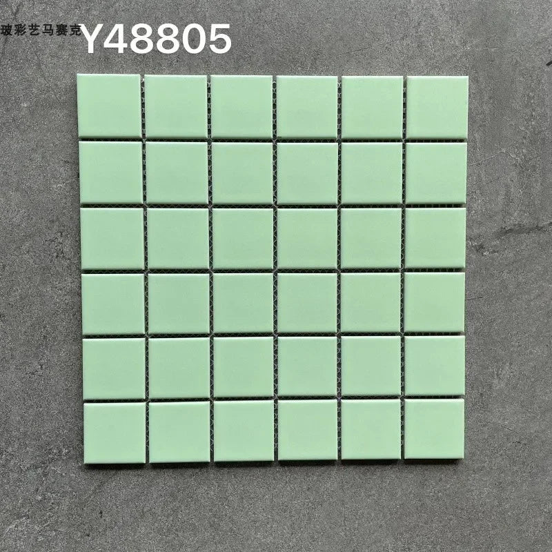Light mint green ceramic mosaic tile sheet with small square tiles and dark grout lines