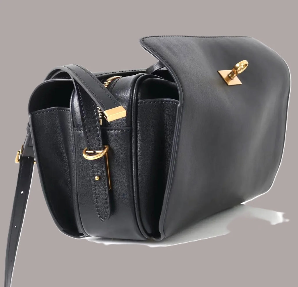 Black genuine leather designer shoulder bag with gold hardware, flap closure, and minimalist waterproof classic design.