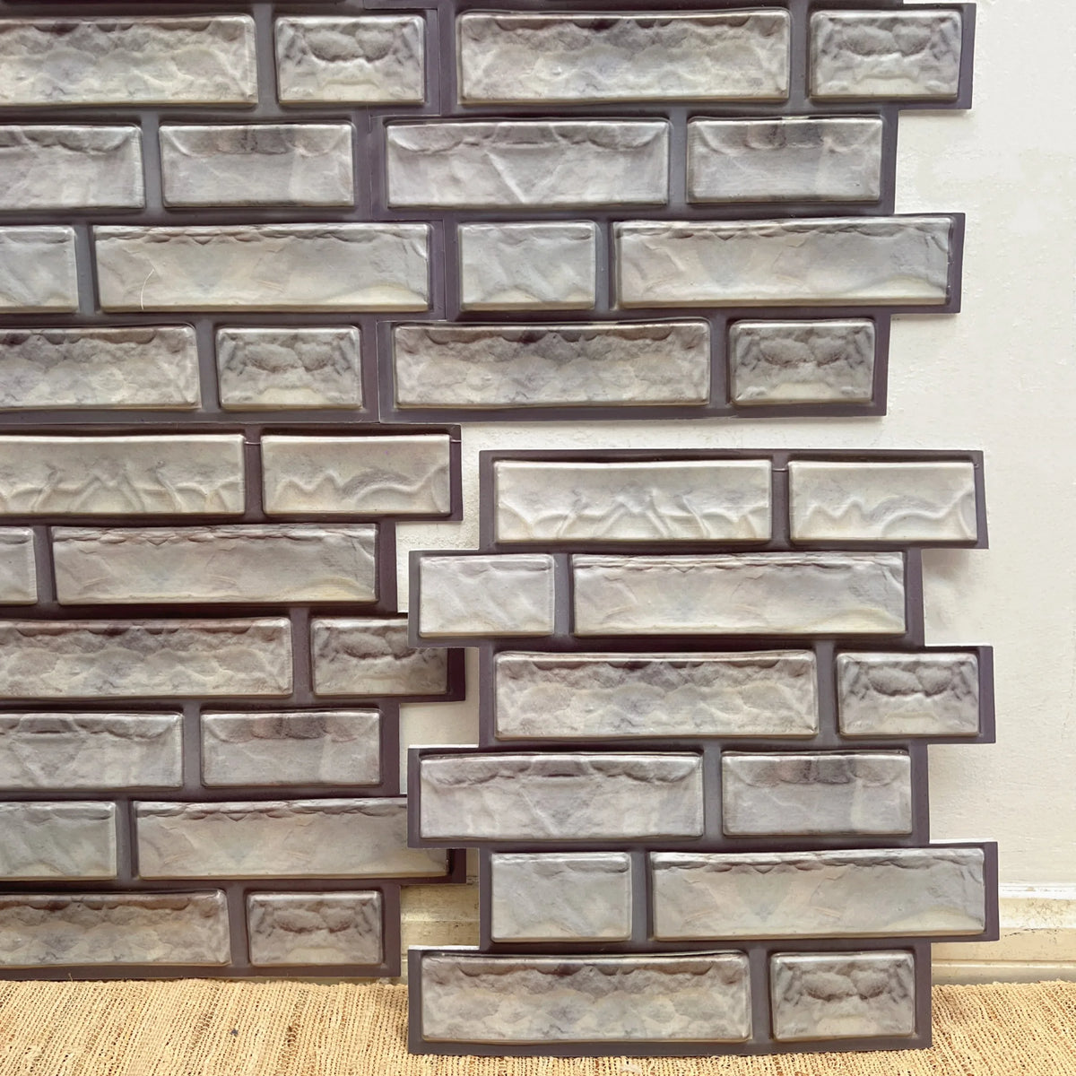 Peel-and-stick brick-style backsplash tiles in white with taupe borders
