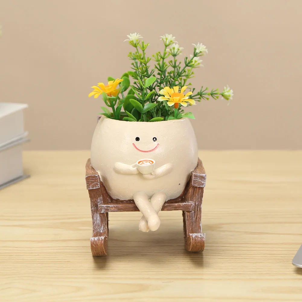 Rocking swing planter pot with smiling face and small potted plants