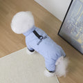 Small dog wearing a light blue waterproof winter jumpsuit with leash attachment for warm, cozy outdoor walks.