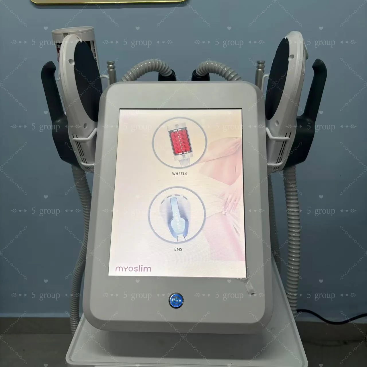 Myoslim body contouring device with a touchscreen interface, two attached applicators, and massage rollers for spa use.