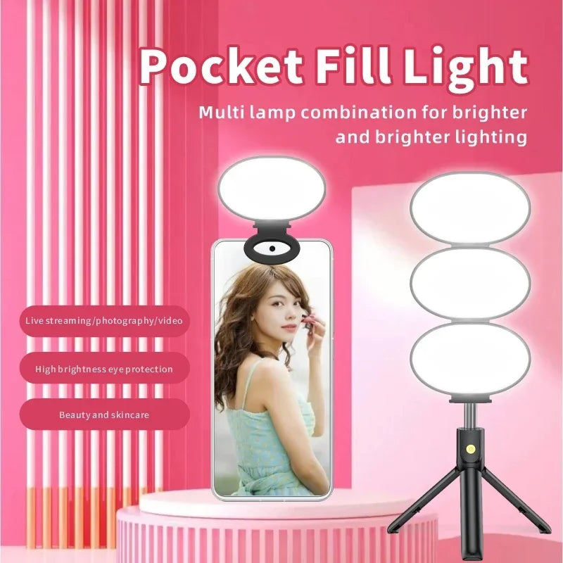Small LED fill light with three oval panels on a black tripod stand, designed for mobile phone photography and video.