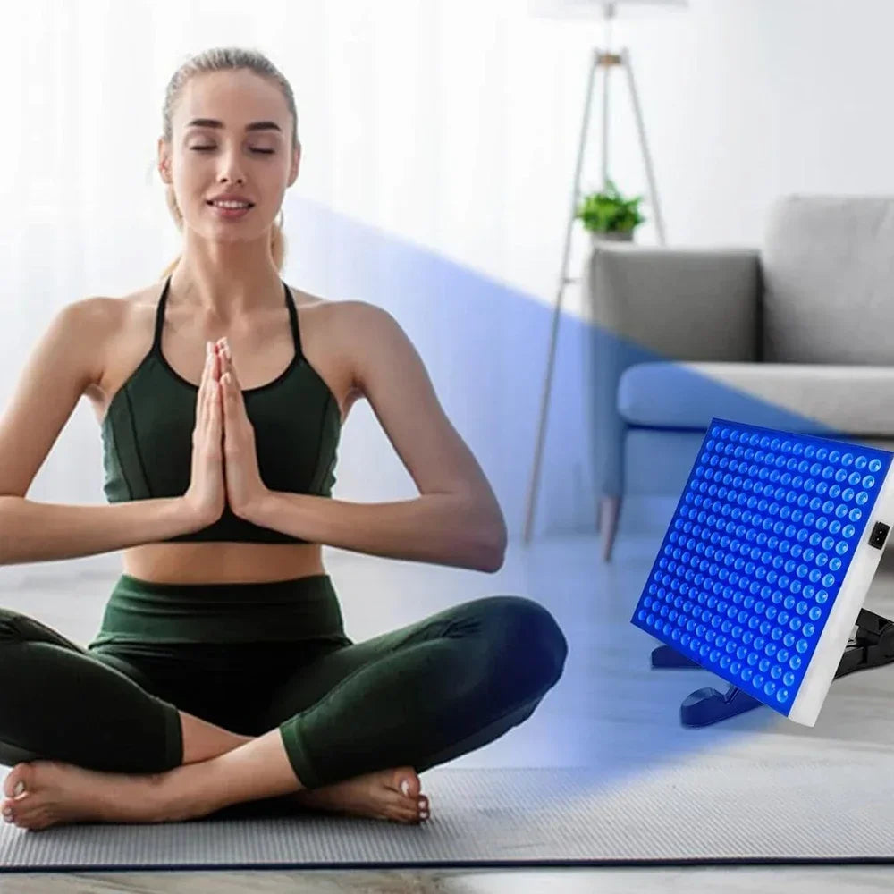 Woman meditating near 225-LED UV solarium tanning lamp with adjustable stand for home skin care in living room.