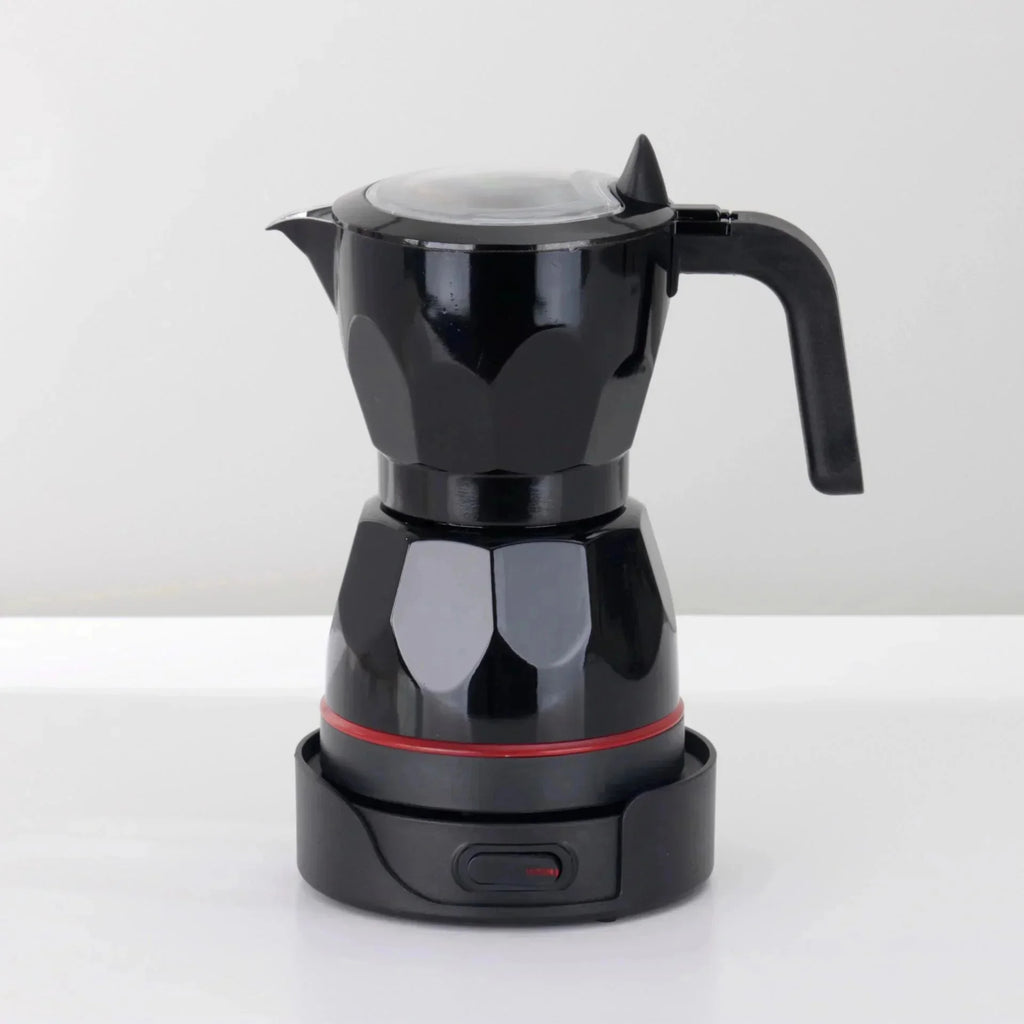 Black electric moka pot coffee maker with faceted design, glass lid, and base with power switch on white background.
