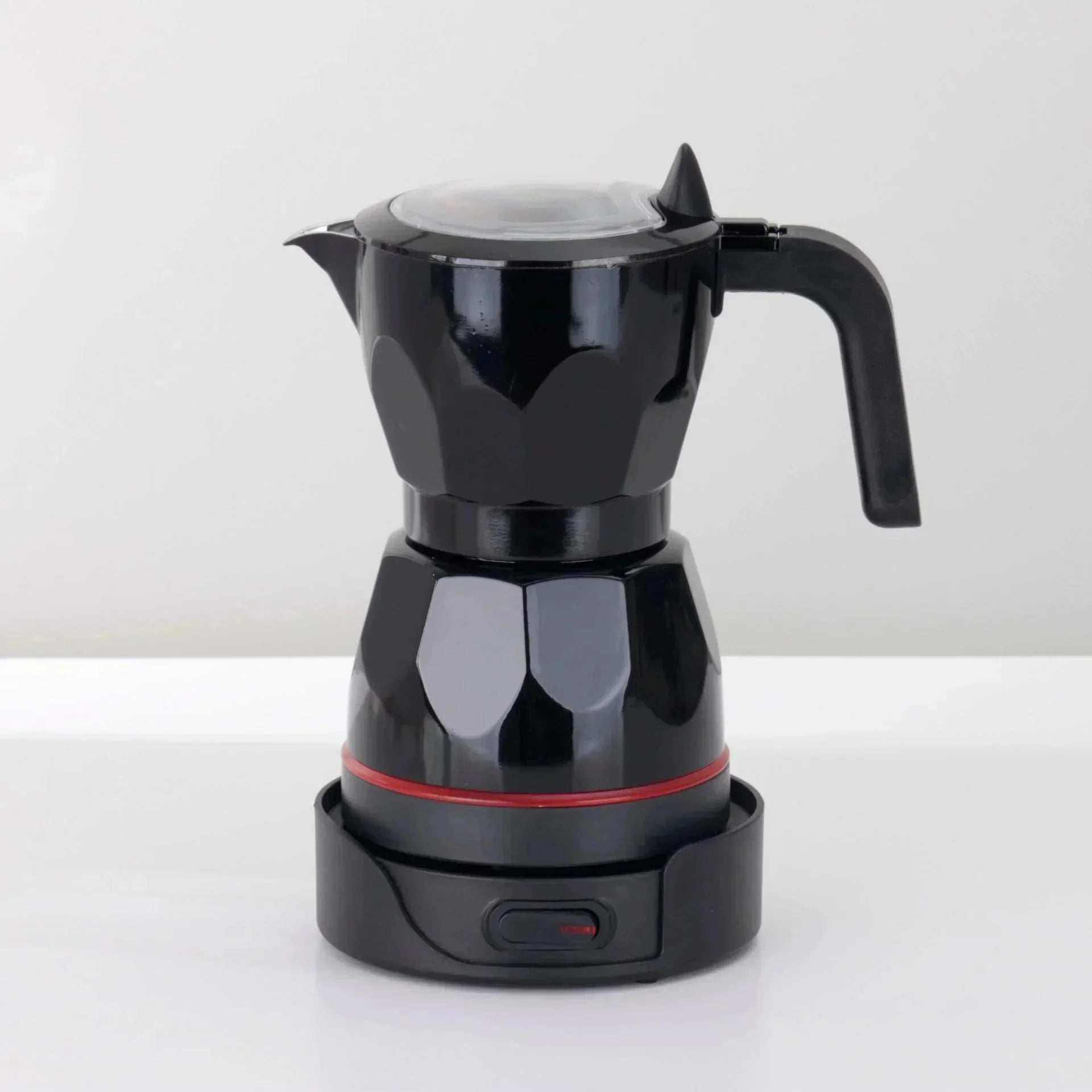 Black electric moka pot coffee maker with faceted design, glass lid, and base with power switch on white background.