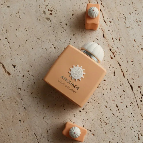 Extrait de parfum bottle, peach glass with white cap and embossed emblem