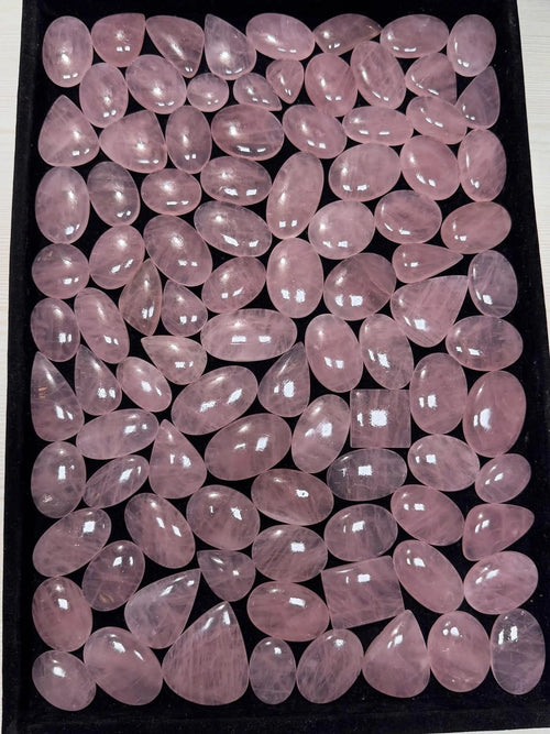 Assorted rose quartz cabochon stones in light pink, oval cabochons with smooth shine