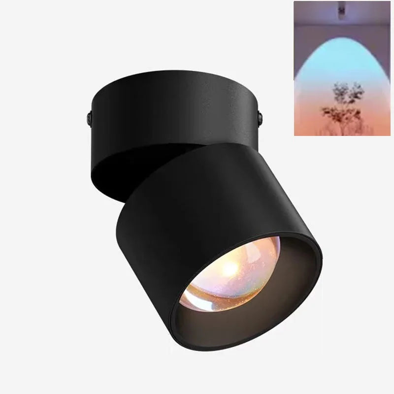 Black LED ceiling surface spotlight with angled cylindrical head and warm lit lens