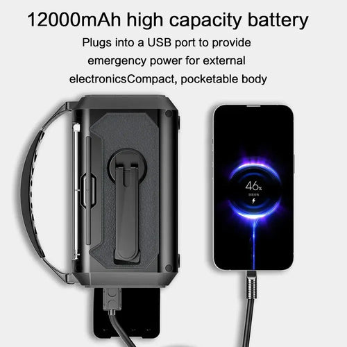Black compact emergency radio with a hand strap charging a smartphone via USB cable against a plain background.