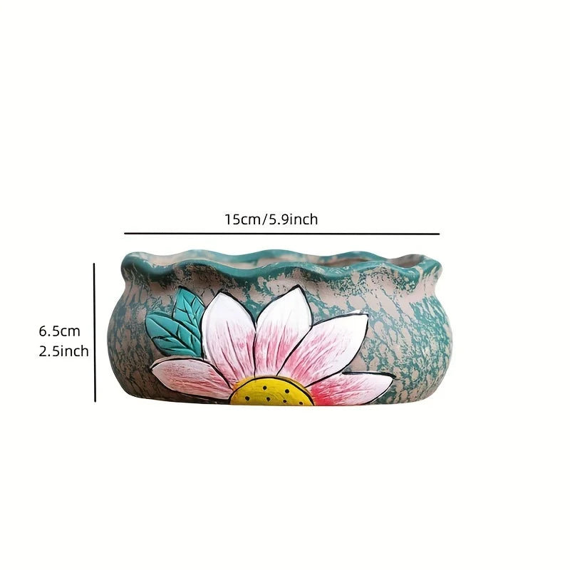 Turquoise ceramic oval planter with pink flower and green leaf design, side view