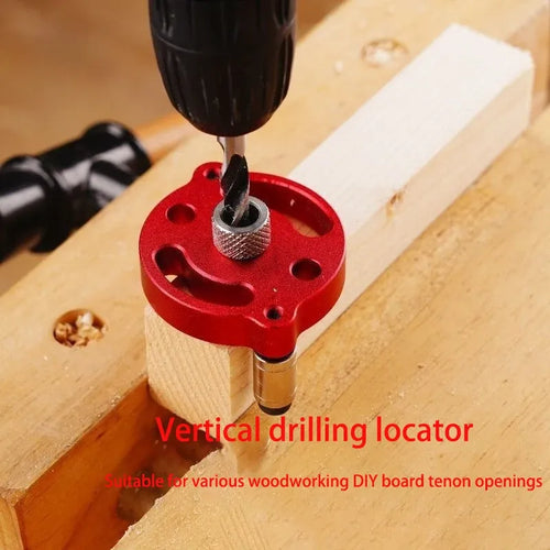 Red vertical drilling locator jig on a wooden board with a drill bit aligned over a hole
